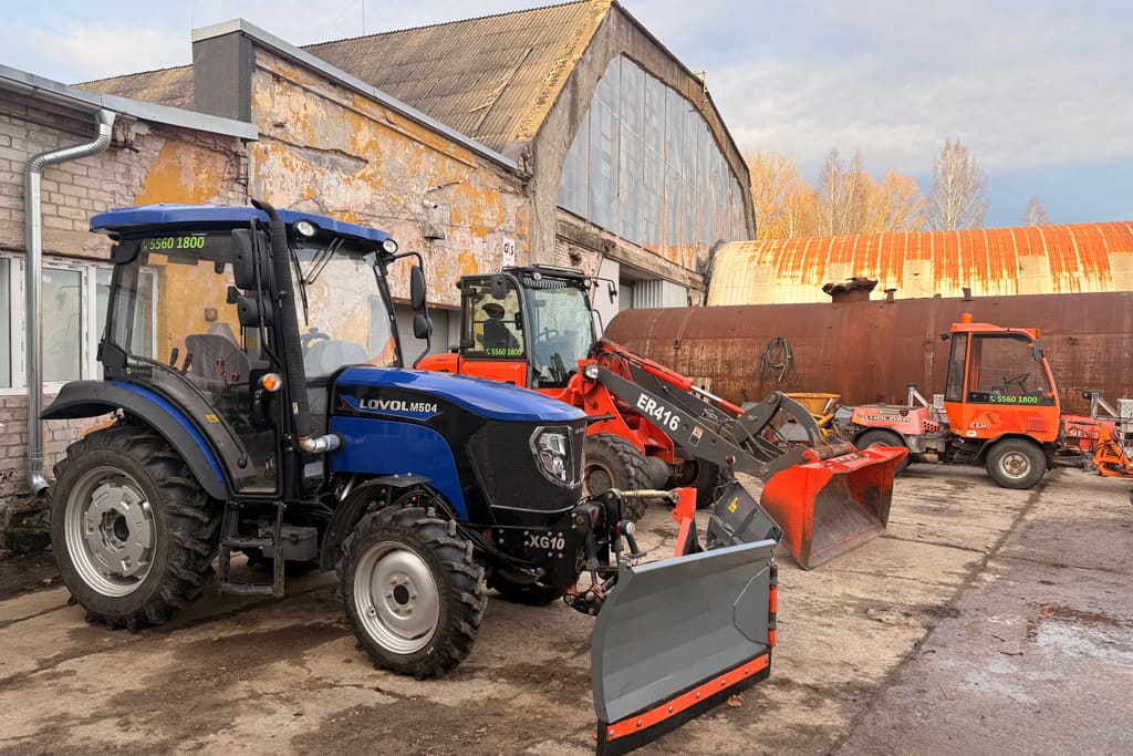 Traktor lumesahaga ja rataslaadur baasi platsil kõrvuti